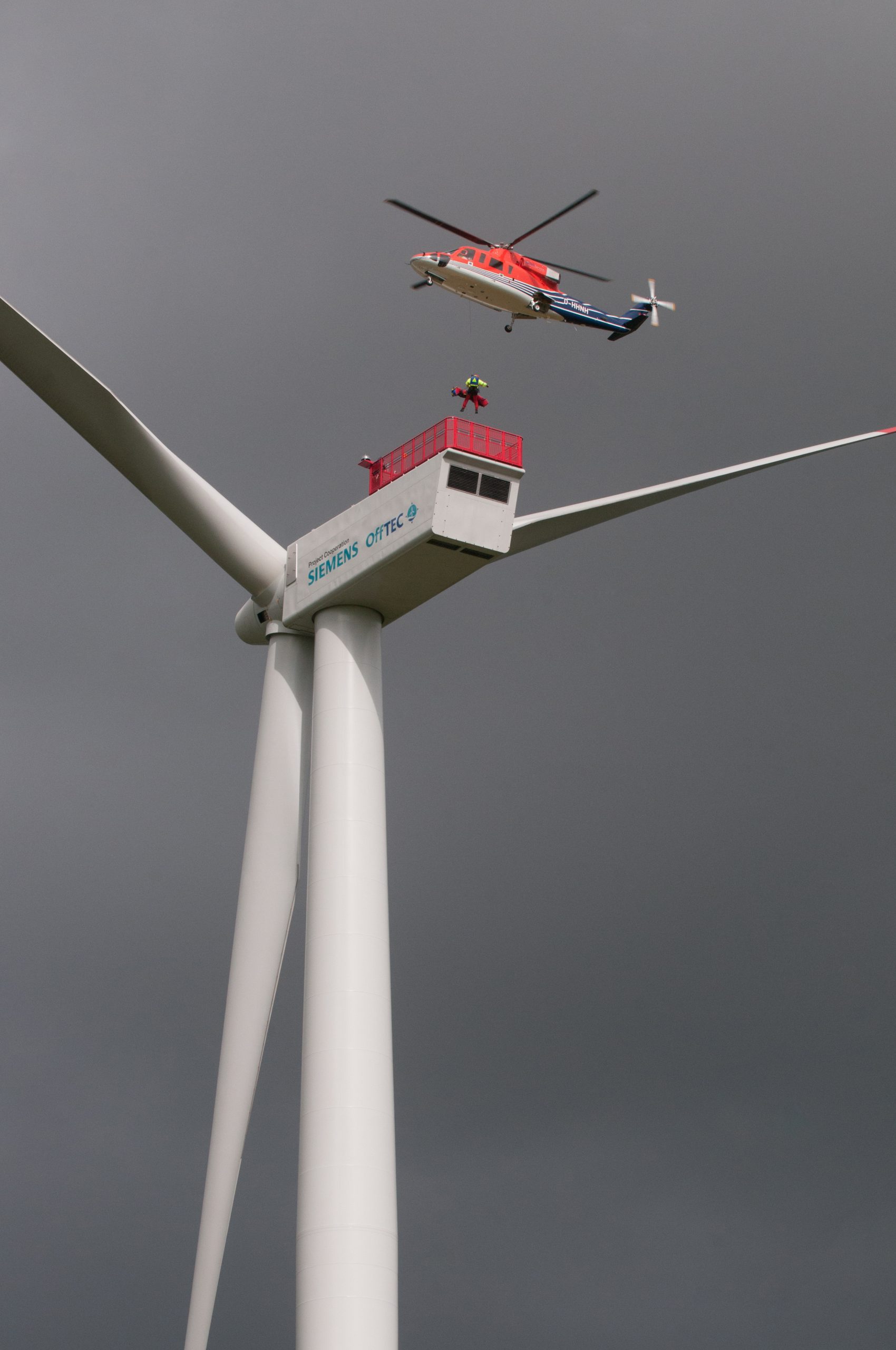 19.09.2012, Enge-Sande. Die Fa. Offtec organisiert Sicherheits- und Technik-Trainings im Bereich Windenergie, vor allem fuer den Offshore-Bereich. An einer Offshore-Windkraftanlagen des Typs Siemens SWT-3.6-120, die u.a. zu diesem Zweck an Land in Kuestennaehe gebaut wurde, wird mit einer Sikorsky S-76 Spirit des US-amerikanischen Herstellers Sikorsky Offshore Helikopter- Hoist- und Rettungsdemonstration durchgefuehrt.

Siemens Hubschrauber PresseONLY Wirtschaft Technik Technologie technisch technologisch Rettung Hoehenrettung Abseilen ueben Uebung Maschine Maschinen Maschinelle maschinell See Meer maritim maritime Nordsee Westkueste Nordfriesland Energie Energien Energieversorgung Energiewirtschaft Strom Stromerzeugung Stromversorgung Kraftwerk Energiequelle Anlage Anlagen erneuerbare neue Oekostrom saubere sauber regenerative regenerativer regenerativ Oekostrom Oeko new energy sauberer Minikraftwerk oekologisches oekologisch Kleinkraftwerk gruener gruen Biostrom Energiewende Nachhaltig Nachhaltigkeit nachhaltige WKA Windrad Windraeder Windenergie Windkraft Windkraftanlage Windkraftanlagen Windstrom WEA Wind Windraeder Windrad Windenergieanlage Windenergieanlagen Windpark Rotoren Rotor Helikopter Hochformat HF Außen Außenaufnahme draußen Aussen Aussenaufnahme 

 Copyright/Foto:grafikfoto.de